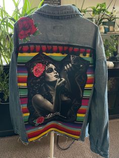 a jean jacket with an image of a woman holding a rose on the front and back