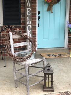 a white chair sitting on top of a porch next to a blue door with a welcome sign above it