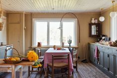 a kitchen with sunflowers on the table and other items in the room around it