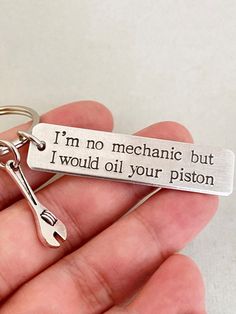 a hand holding a keychain that says i'm no mechanic but i would oil your piston