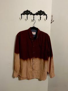 a brown and black shirt hanging from a hook on a wall next to a coat rack