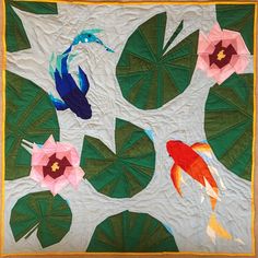 a quilted wall hanging with fish and flowers on it's sides, in the shape of a tree