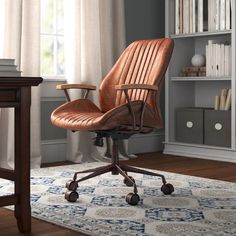 an office chair sitting on top of a rug in front of a book case and desk