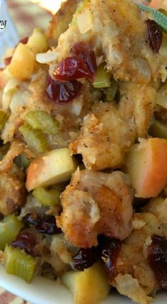 a close up of food on a plate with cranberries and other toppings