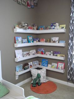 a child's room with bookshelves on the wall and stuffed animals in the corner