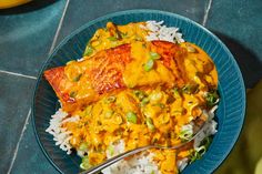 a blue plate topped with fish and rice