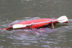 a red kayak floating on top of a body of water