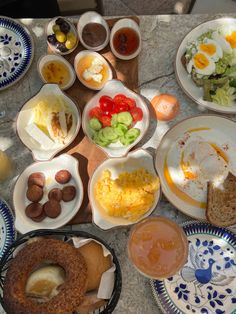 a table topped with plates and bowls filled with breakfast foods on top of each other