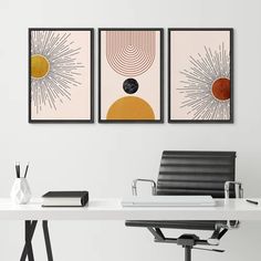 three art prints on the wall above a desk