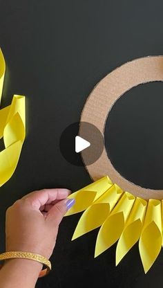 someone is making a paper sunflower wreath