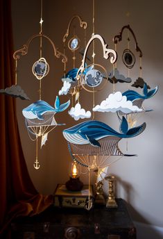 a chandelier with blue and white birds hanging from it's sides in a room