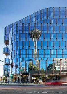 the building has many windows and is reflecting it's reflection in its glass facade