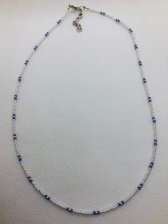 "This beadwork project is a design that is made on nylon coated stainless steel. Different size beads can be used in this design, but this particular one is done with size 11/0 Miyuki glass seed beads. It is not stretchy.  it has a 1\" extension on it. It measures 18.5\" to 19.5\" with extender.  If you would like this bracelet done in a different size or colors, let me know and I'll set up a listing for that.  You are purchasing this actual beaded necklace. Let me personalize some especially for you in your school colors." Adjustable White Beaded Chain, Silver Heishi Bead Jewelry, Handmade Silver Heishi Beads, Minimalist Blue Heishi Beads Jewelry, White Heishi Beads Necklace With Spacer Beads, Blue Heishi Beads With Beaded Chain, White Beaded Chain Bracelet With Heishi Beads, Silver Heishi Spacer Beads, Adjustable Silver Heishi Beads Necklace