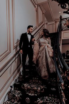 a man and woman are walking down the stairs