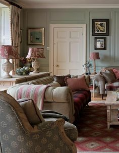 a living room filled with furniture and pictures on the wall above it's fireplace