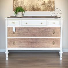 a white dresser with two drawers and a potted plant on top