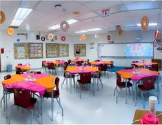 a classroom filled with lots of pink and orange table cloths on top of tables