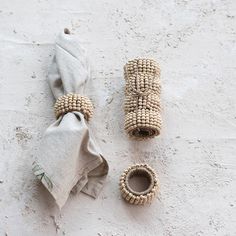 two napkins and some beads on a white surface