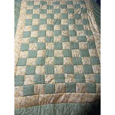 a bed with a green and white quilt on it