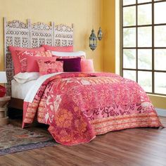 a bedroom with yellow walls and pink bedding