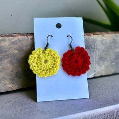 two crocheted flower earrings are displayed on a card