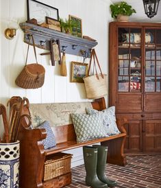 a wooden bench sitting next to a wall filled with pictures and other items on top of it