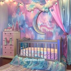 a baby's room decorated in pink, blue and purple with a crescent moon painted on the wall