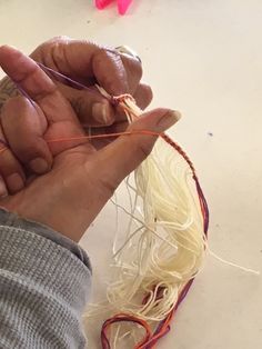 a person is working on something with yarn