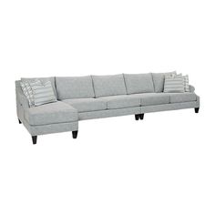 a gray sectional couch with pillows on the top and bottom end, sitting against a white background