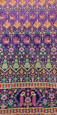 an intricately designed purple cloth with colorful flowers and birds in the center, on top of