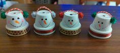 three snowmen sitting on top of a wooden table