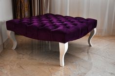 a purple bench sitting on top of a marble floor next to a curtained window