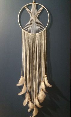 a white dream catcher hanging on the wall