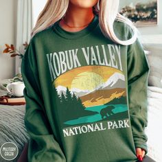 Show off your love of Alaska and one of our nation's most majestic national parks in our Kobuk Valley National Park Sweatshirt! This comfy crewneck is all about embracing the great outdoors, featuring a custom vintage design that showcases the grandeur of the Alaskan Wilderness and the vast mountain terrain of the Kobuk Valley itself! The Gildan 18000 50/50 blend fabric has that comfy, lived-in feel, that's like a hug every time you put it on! Now you can take a bit of Kobuk with you wherever yo Ohio Sweatshirt, National Park Sweatshirt, Maine Trip, Cuyahoga Valley National Park, National Park Gifts, Maine Vacation, Tree Sweater, Blue Ridge Parkway, Beautiful Park