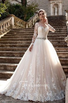 a woman in a wedding dress standing on some steps