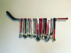 a hockey stick is hanging from the wall with medals on it's side,