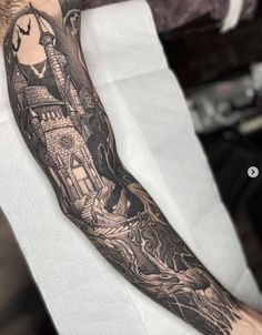 a man's arm with a castle tattoo on it