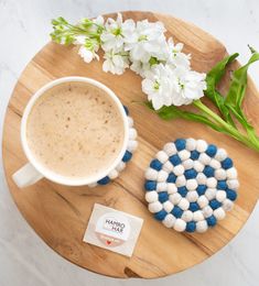 a cup of coffee sitting on top of a wooden table next to marshmallows