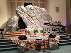 a stage set up for a concert with rock formations and microphones in front of it