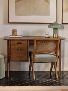 a desk with a chair, lamp and painting on the wall