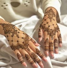 a woman's hands with henna tattoos on them