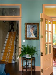 an open door leading to a living room and dining room with stairs in the background