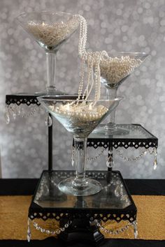 two martini glasses filled with pearls on a table