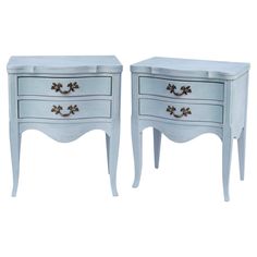 two white nightstands side by side with gold hardware on the top and bottom drawers