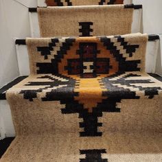 a carpeted stair case with black, yellow and brown designs on the treads