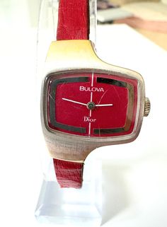 Ladies fantastic retro chic rare designer watch  70's Christian Dior x Bulova collaboration   hand-wound wristwatch. With new battery fitted  Working item, With original leather strap lots of life left  Some scratches on the facia from age and ware not very noticeable  when on  iv used a highlighted function on camera so you can see  May be able to polish out at a jewellers  Color Vintage wine Bordeaux with silver case and gold accents on facia  size  Case width 2.9 x height 2.8 Lug 8mm Hand Wound, Vintage Wine, Color Vintage, Retro Chic, Wrist Watches, Watch Design, Gold Accents, Vintage 70s, Christian Dior