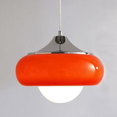 an orange pendant light hanging from a ceiling