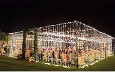 an outdoor wedding venue decorated with lights and greenery for the guests to sit on