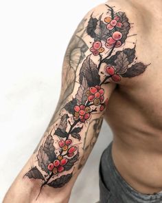 a man's arm with flowers and leaves tattooed on the left side of his body