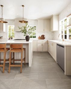 a kitchen with white cabinets and wooden stools